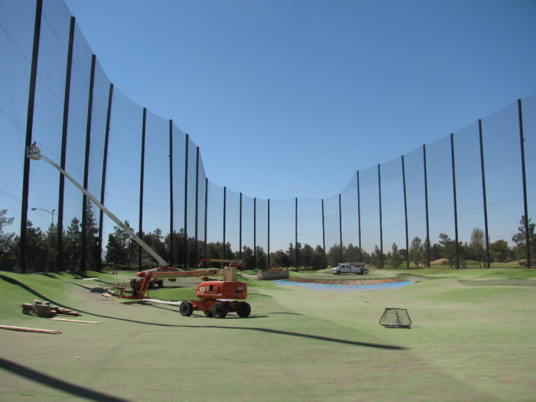 Tall netting and support poles at a golf facility